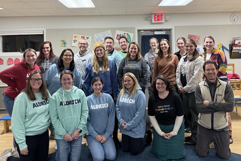 Group of people standing and kneeling together, wearing Aldrich School Apparel, the Aldrich Board of Directors
